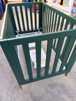 Baby crib, changing station and in emerald green and gold accents
