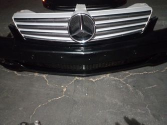 2006-2009 Mercedes CLS Series Complete Front Bumper With Grills And Emblem And Fog Lights With Accessories And Parking Assistance Sensors OEM.