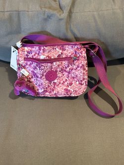 This is a Kipling Alenya crossbody bag in a vibrant pink floral "Trio Sketch" print.