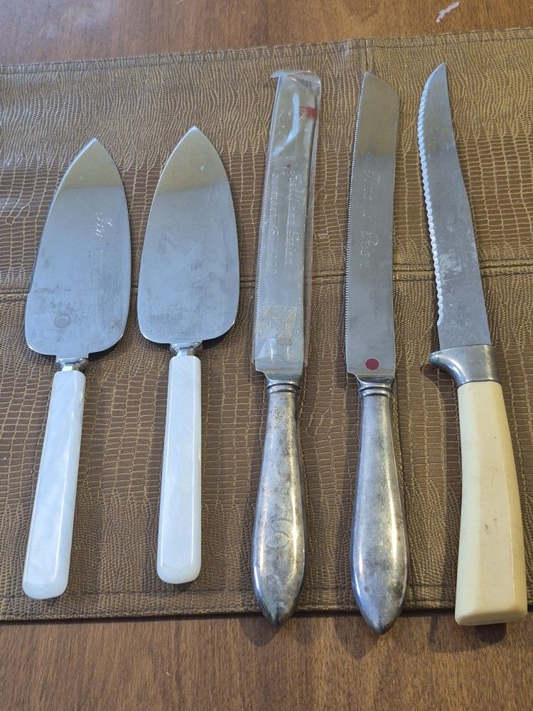 Three stainless steel wedding cake, knives, and two stainless steel servers