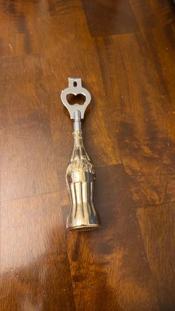 Coca-Cola bottle opener top silver Cole bottle is gold color