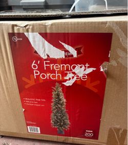 A pre-lit artificial entrance/potted Christmas tree packed inside its original storage box, resting in styrofoam formatting pieces above its decorativ