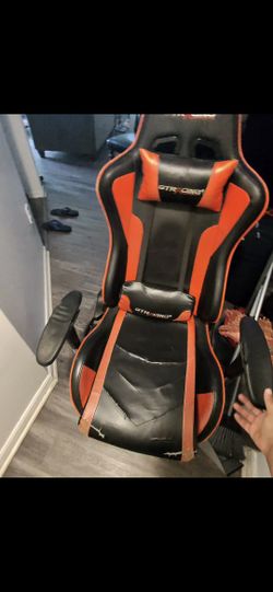 Worn down gaming chair with footrest and speakers