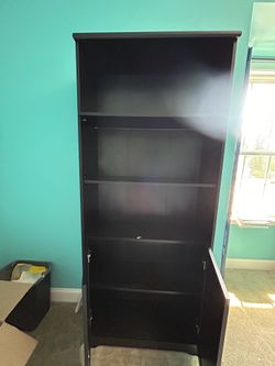Black wood book case with cabinet doors for $32