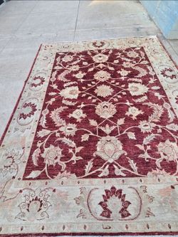 This Peshawar Oushak-style rug features a traditional floral design, hand-knotted in wool.