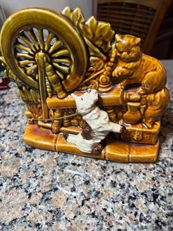 This is a vintage 1950s McCoy pottery planter featuring a glossy brown glaze, a raised spinning wheel, and a playful Scottie dog and cat… $35
