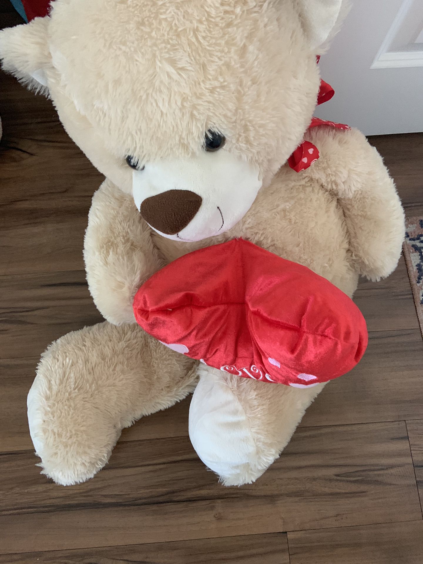 plush tan teddy bear holding a red heart that says "I Love You."