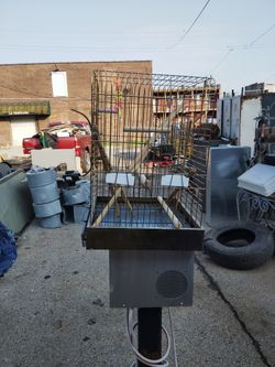 A Parrot Cage With Wooden Rods For Standing Sitting And Crawling Around With