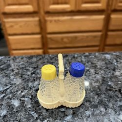 Vintage Small Clear Glass Pair of Salt and Pepper Shakers with Plastic Celluloid Carrier .  Size approximately shakers 2 1/4 inches tall.  Preowned  
