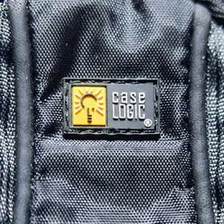 Mini Black (Case Logic) Camera Bag • Has Belt Strap Loop In Back • 2- Zippered Pouches • Blue Padded Interior • Bag Measures : 4"-Long X 2"-Wide X 5"-