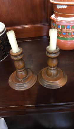 Two wooden candle holders with used candles