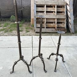 Three heavy iron candle holders