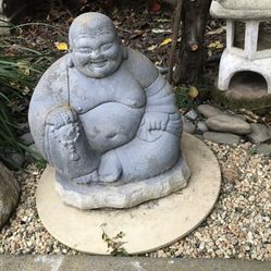 A small cement Asian Buddha garden statue