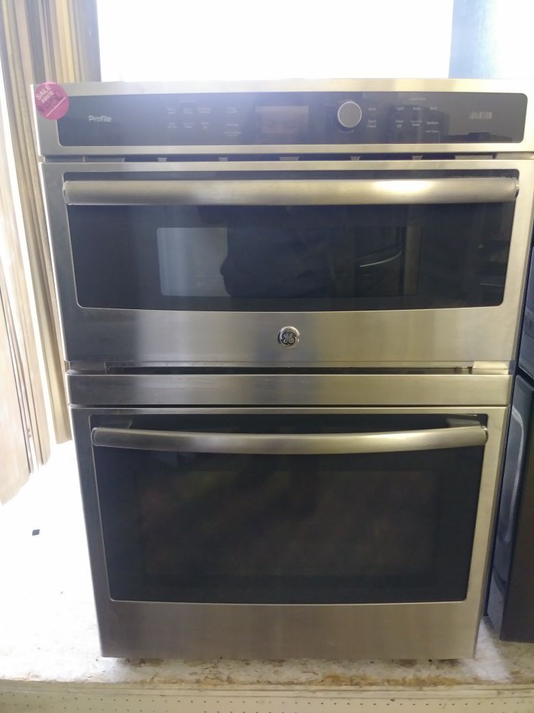In wall mount GE black and stainless steel oven with microwave