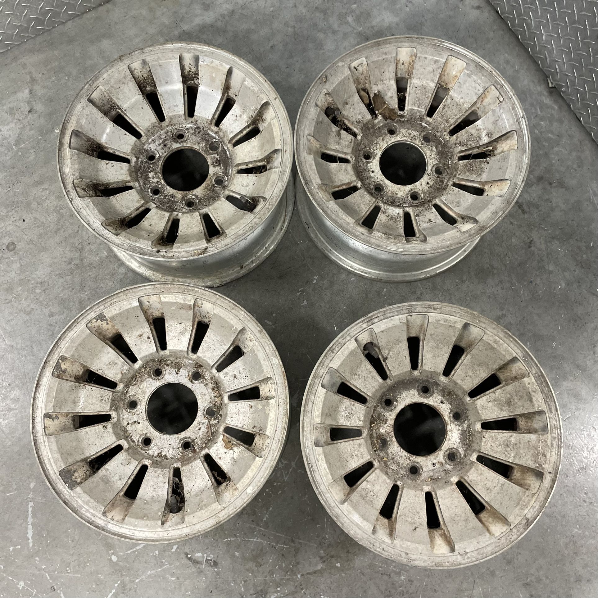 Set of four 15x7 inch factory aluminum wheels from an old Jeep Grand Wagoneer