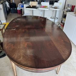 oval mahogany dining table in a Louis XVI style, featuring brass trim, brass-capped feet