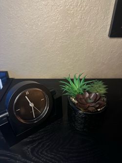 Black desk clock and artificial succulent