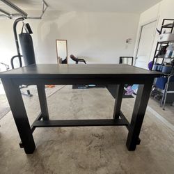 The dark brown wooden dining set has one of the supports damaged because the dog chewed it, but the