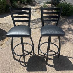 A Set Of Black Bar Height Swival Stools