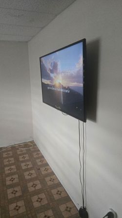 Used Samsung TV on wall includes ROKU AND THE MOUNTING UNIT