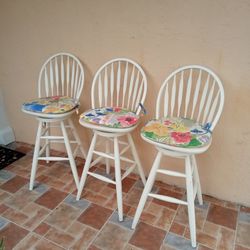THREE SOLID WOOD COUNTER HEIGHT SWIVEL BAR STOOLS WITH CUSHIONS