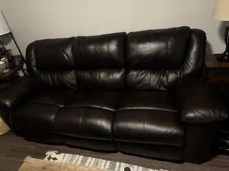 Three seat reclining, faux, leather sofa. Dark brown. Middle seat back folds down for tray/cupholders.