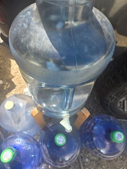 Botellas de 5 galones para agua con dispenser y una base se madera , usados pero en buenas condiciones en venta son un total de 7