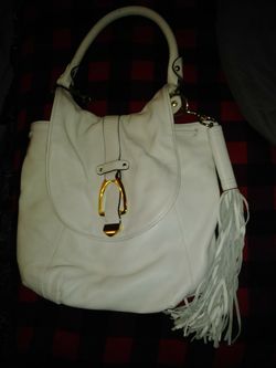 Super cute gently used white leather purse with removable tassle. No damage at all. Like new. Theres a couple little pen marks inside but thats it.