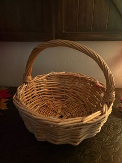 round, hand-woven natural wicker gathering basket with a sturdy single overhead handle