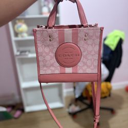 Coach Dempsey Tote 22 in Signature Jacquard with Stripe and Coach Patch in a pink color variant. 