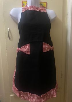 delantal de cocina estilo vintage de color negro con detalles de cuadros vichy rojos y blancos.