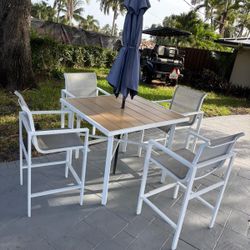High top chairs and patio table outdoors with umbrella