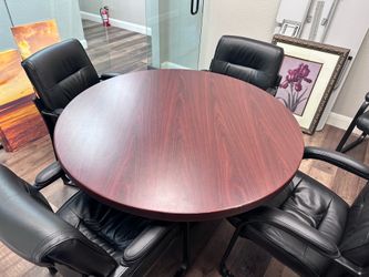 Round conference table with four black chairs