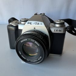 Pentax ZX-M 35mm SLR film camera equipped with a Ricoh Rikenon P 1:1.7 50mm lens. 