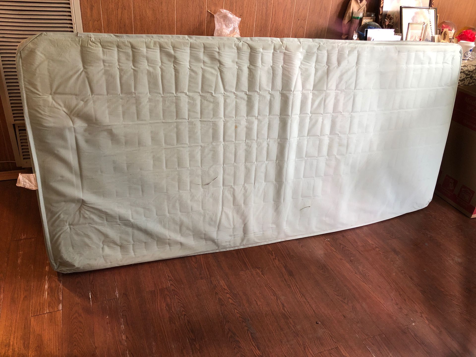 Twin bed mattress (plastic covering).