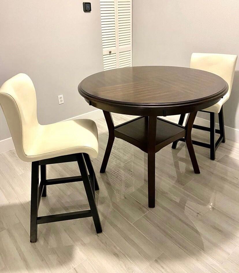 Wooden round table with two swivel chairs