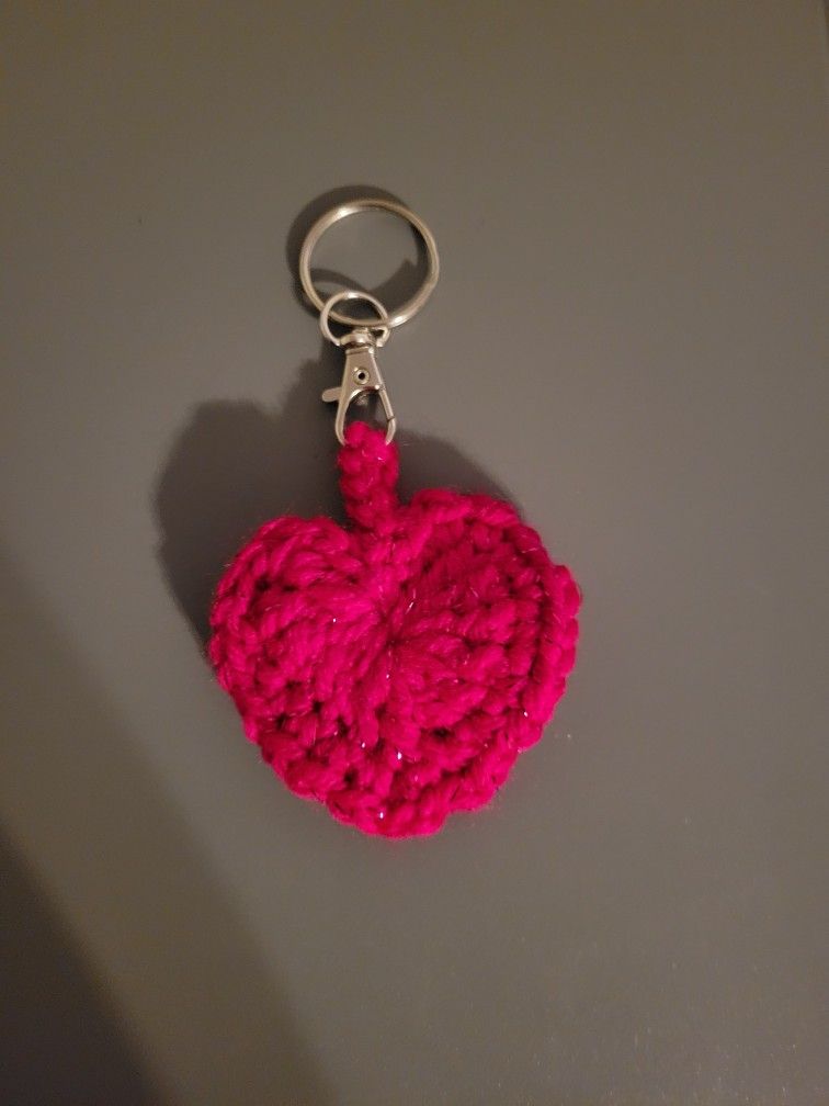 Crocheted heart keychain made with pink yarn with a metallic thread