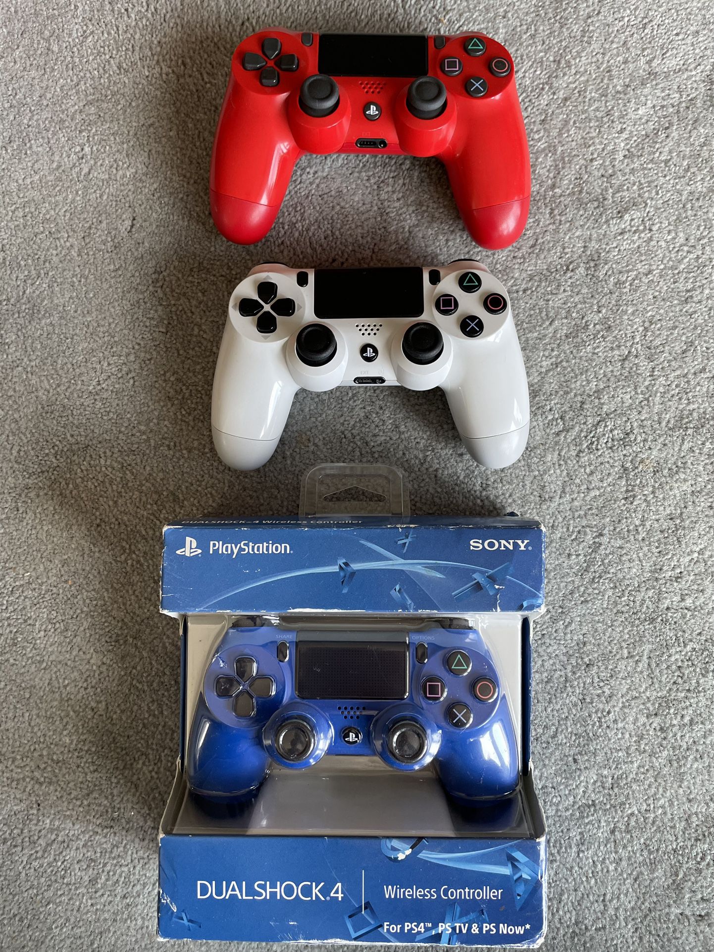 red, white and blue DualShock 4 controllers