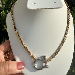 Gold and silver links and a contrasting horseshoe shackle clasp.