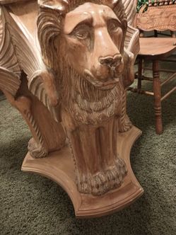 Lion table 4 chairs.The glass top is fifty two inches around hand carved on the lions are three heads under the table
