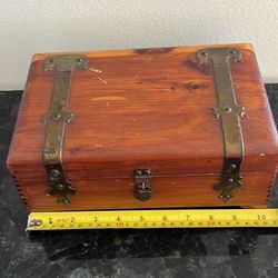 vintage cedar wood jewelry or trinket chest with metal straps and hardware. 