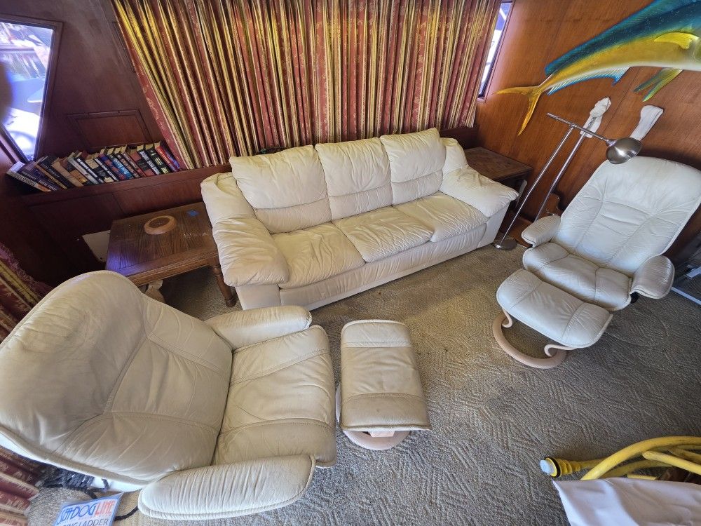 White leather couch and two reclining chairs with footstools