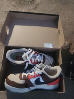 Nike SB Dunk Low Panda sneakers in brown, white, and red with a black Nike swoosh #skateboarding #panda