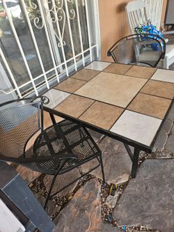 Mesa de tallo con sillas de fierro