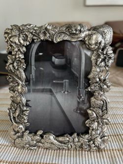 Charming silver-tone vintage-style photo frame featuring raised flowers and bunny details in excellent condition! Measures 6" x 4.5", includes velvet