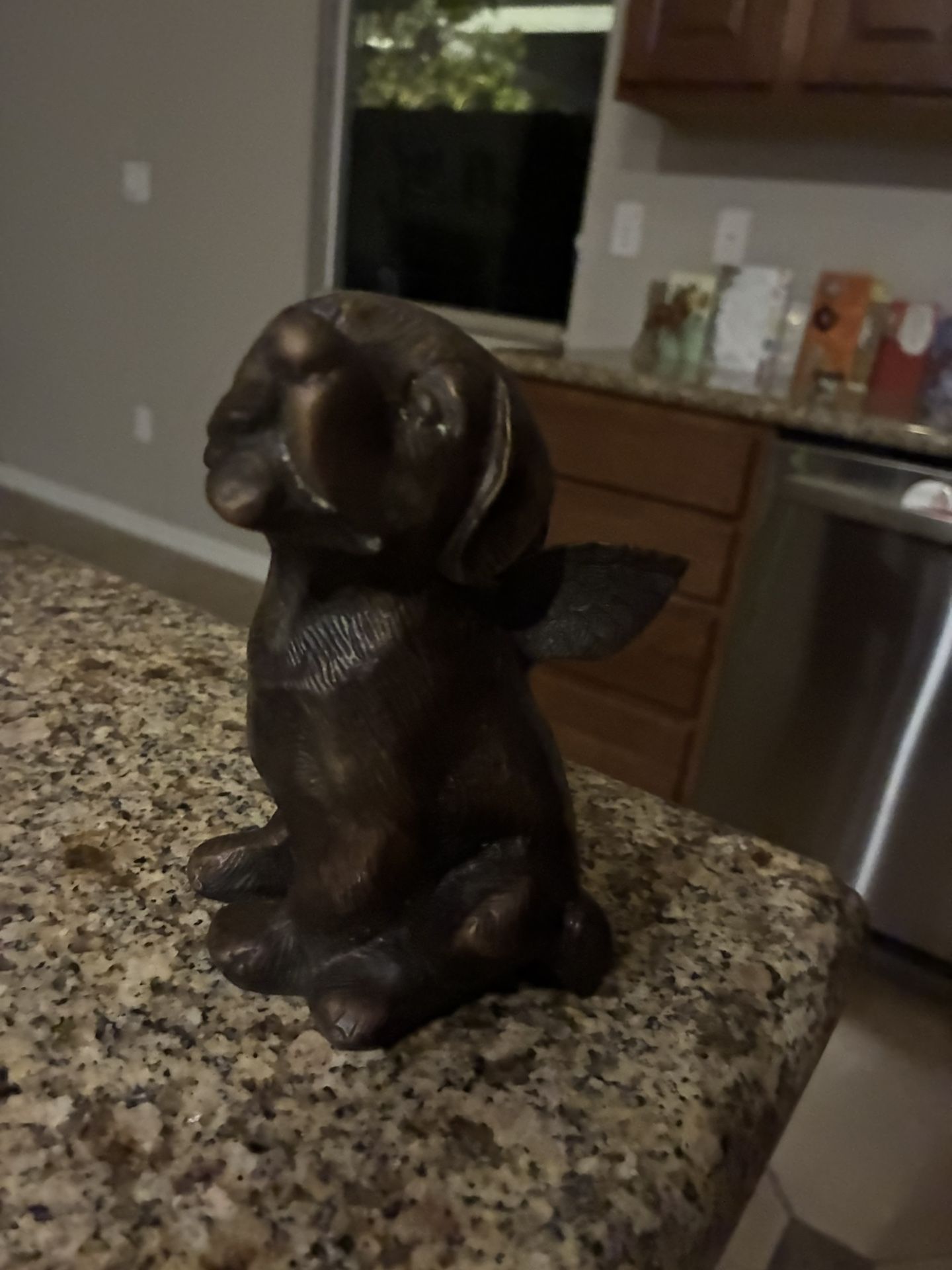 Bronze sculpture of a dog with wings
