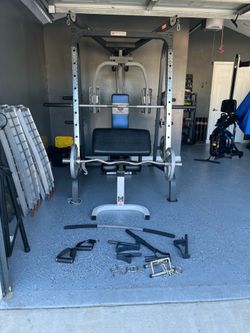 Marcy home gym/ Smith machine with adjustable bench with many attachments and 280 pounds in weight.