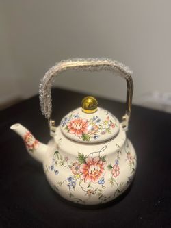 Charming teapot with pretty floral design. Cream color with pink, blue, yellow flowers. Gold handle