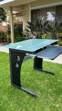 32W*23D *30H Techni Mobili desk features a tempered  glass top and a slide
