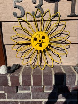 Handmade metal flower wall art crafted from a vintage farm machinery part rotary hoe wheel